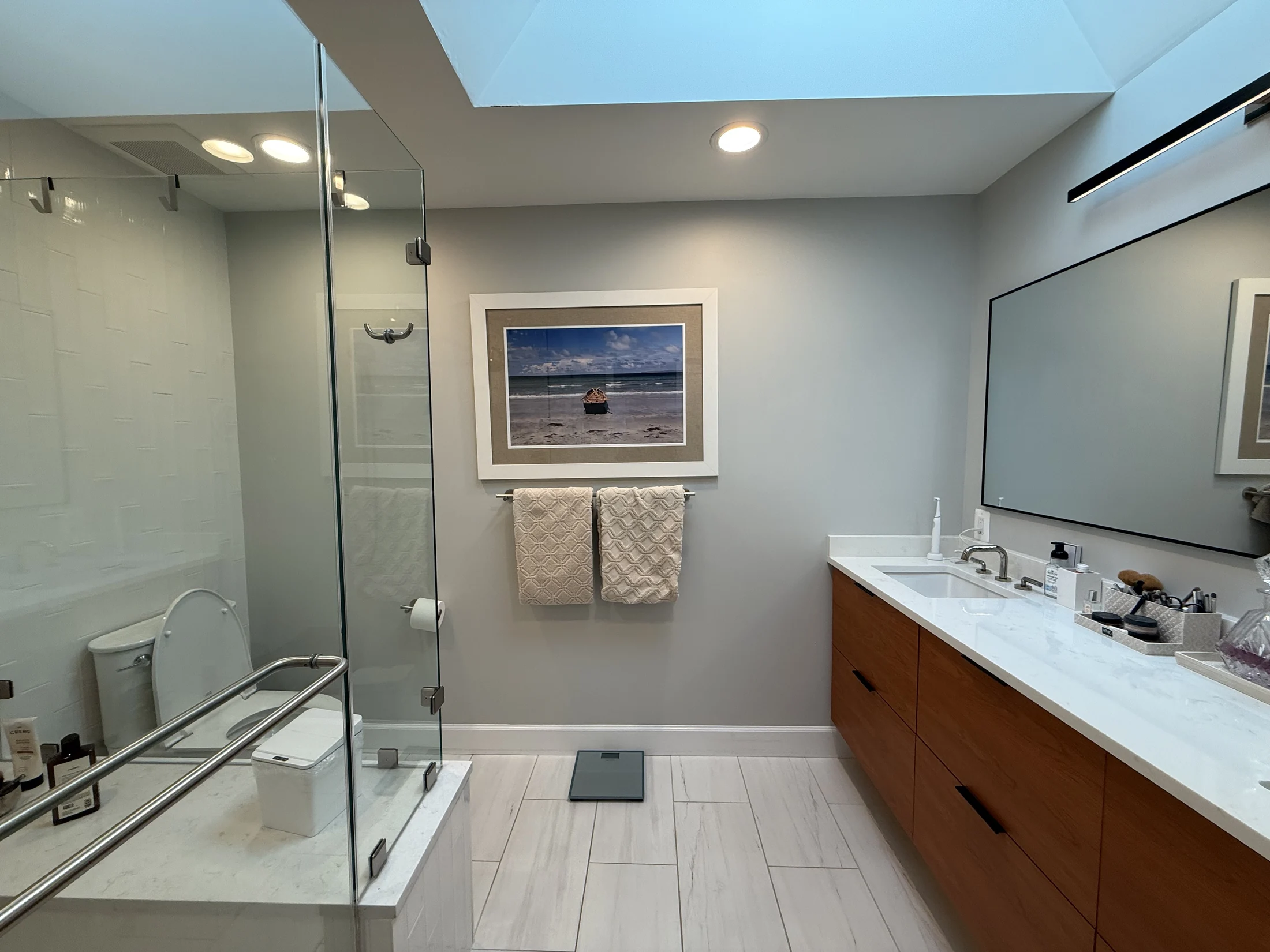 Expanded primary bathroom with a glass shower and wood vanity