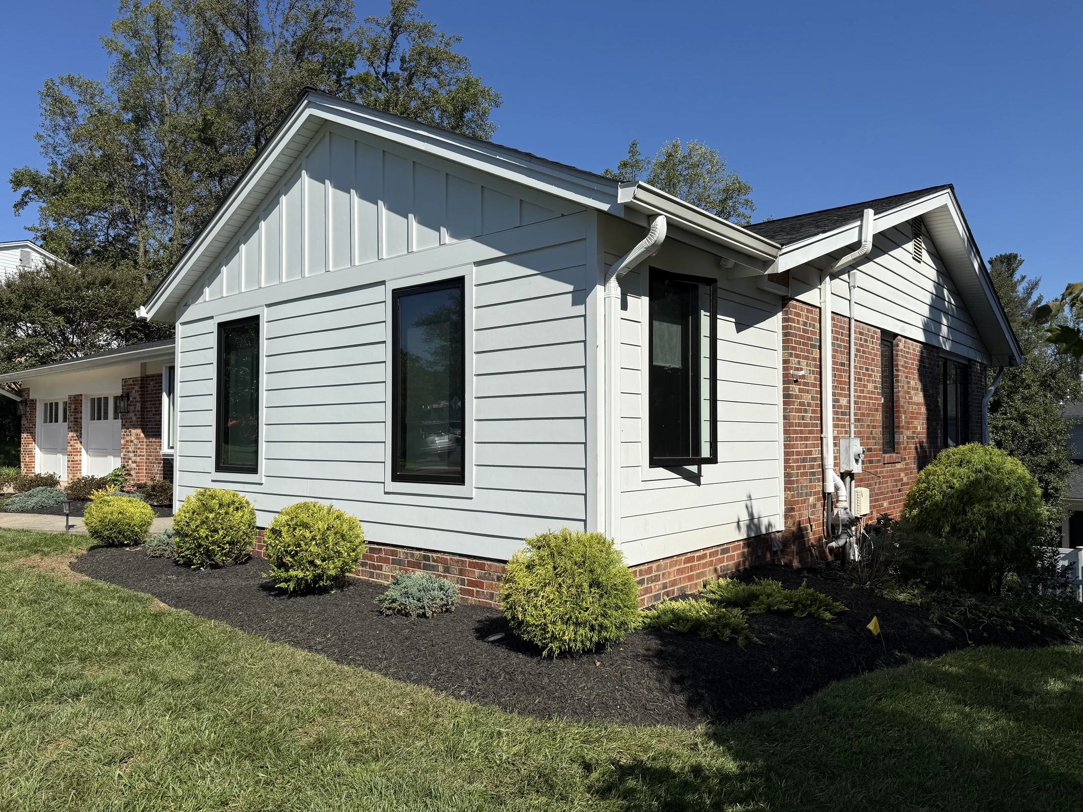 Gable siding, windows, and brick foundation details