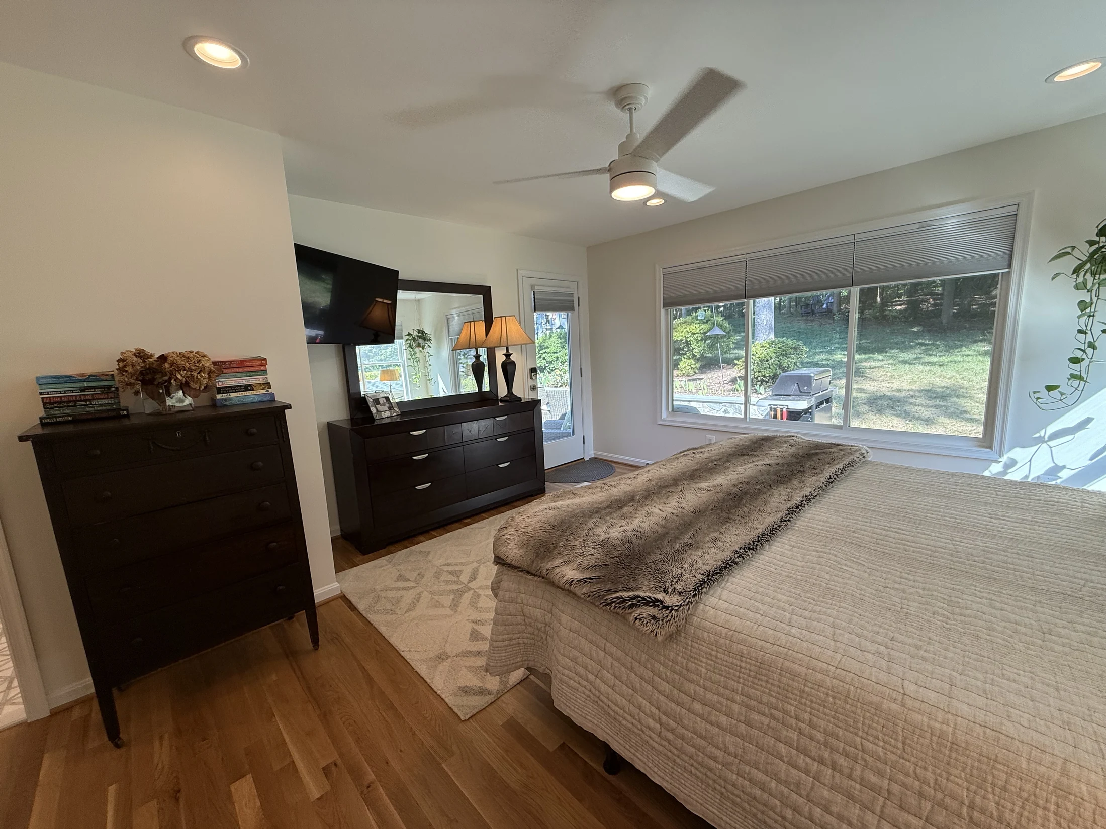 Primary bedroom with a broad window overlooking the yard