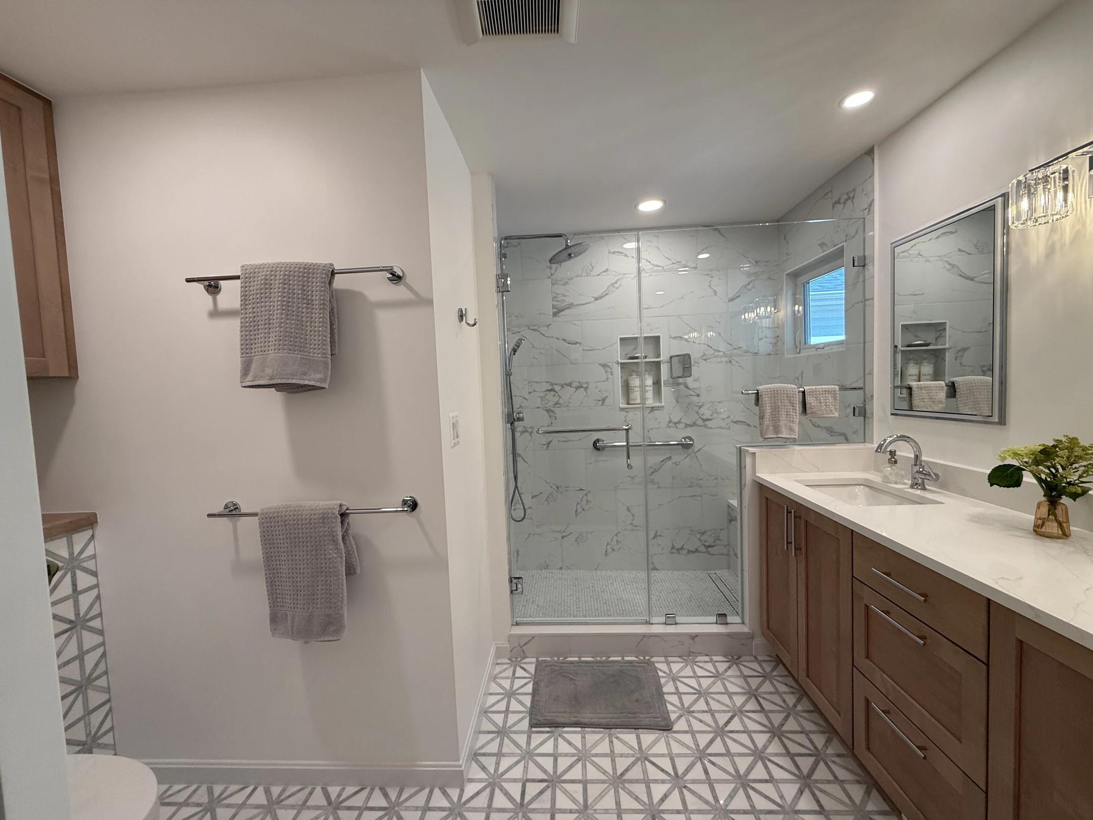 Expanded primary bathroom with a glass shower and patterned floor tile
