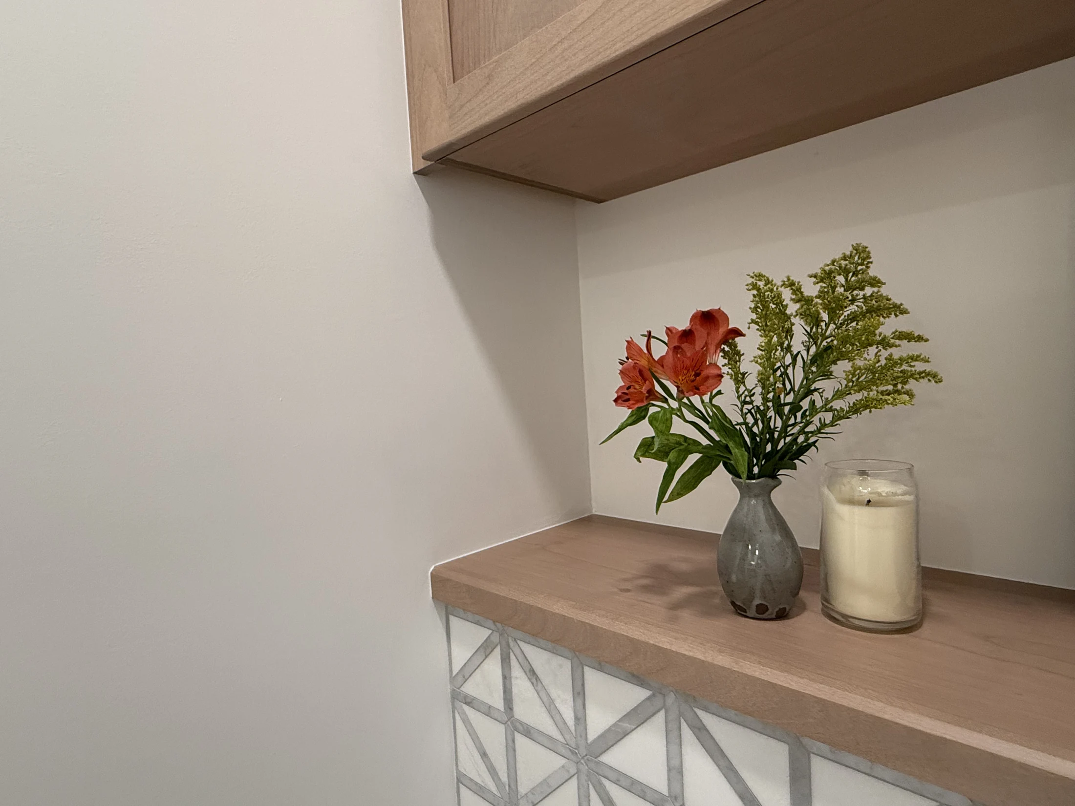 Bathroom cabinet, shelf, and patterned tile detail