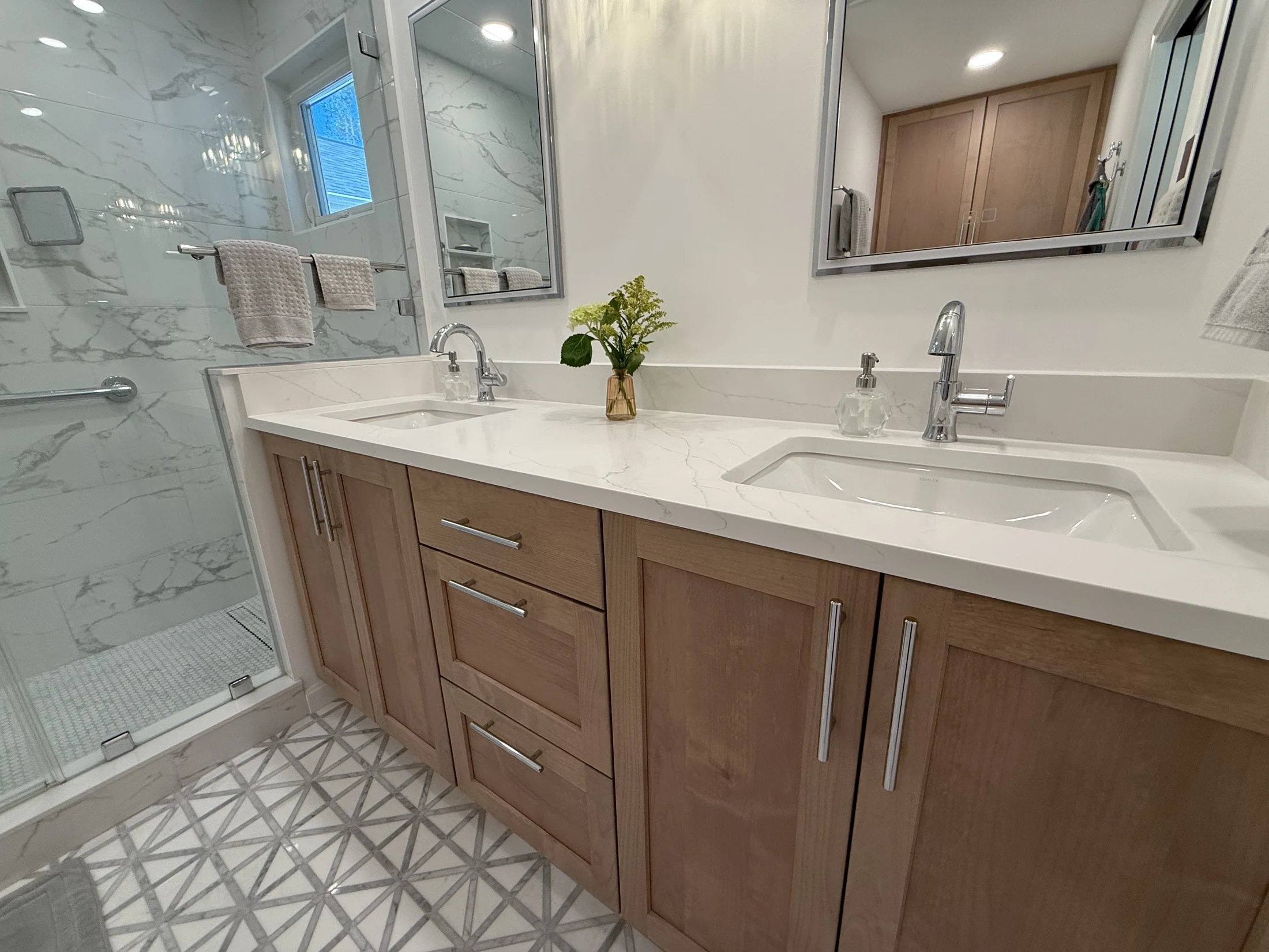 Double vanity with wood cabinetry in the expanded primary bath
