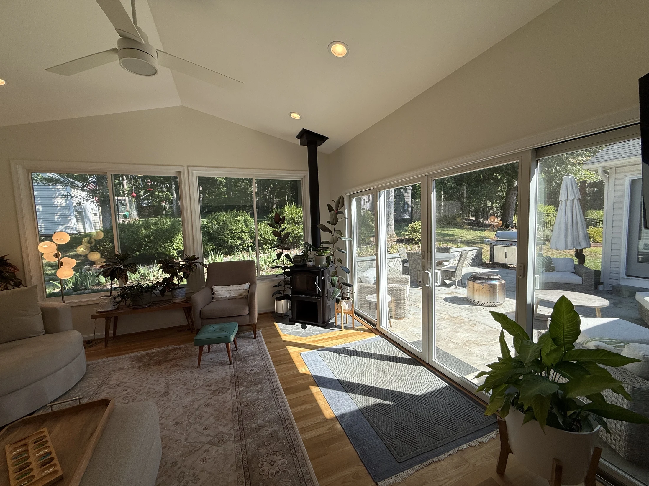 Sunroom with a vaulted ceiling, wood-burning stove, and views to the patio